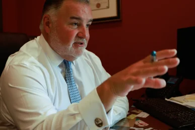 Lawyer joel hamner discusses a motorcycle accident exhibit with a client, noting impact points.