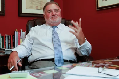 Lawyer joel hamner discusses a paralysis injury exhibit with a client, highlighting spinal cord data.