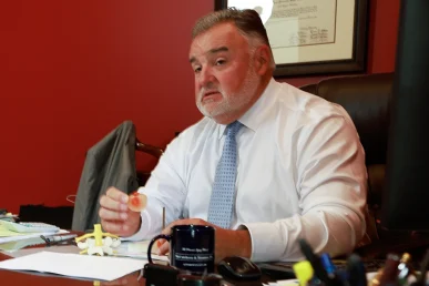 Lawyer joel hamner discusses a tractor accident exhibit with a client, focusing on equipment malfunction data.