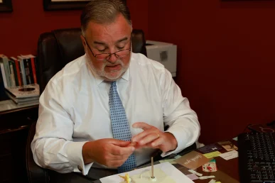 Lawyer joel hamner discusses an airplane accident exhibit with a client, highlighting flight data and safety reports.