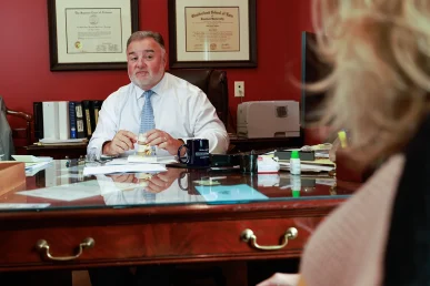 Lawyer joel hamner discusses an electrocution accident exhibit with a client, pointing out wiring hazards.