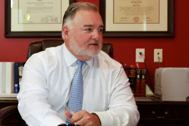 Lawyer joel hamner discusses an uninsured driver accident exhibit with a client, focusing on coverage gaps.
