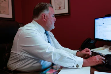 Lawyer joel hamner explains a bus stop accident exhibit to a client, noting pedestrian safety concerns.