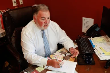 Lawyer joel hamner explains a hit and run accident exhibit to a client, including surveillance images.