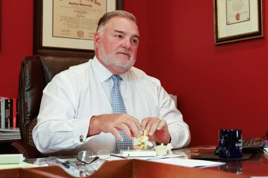Lawyer joel hamner explains a traffic accident exhibit to a client, summarizing roadway hazards.