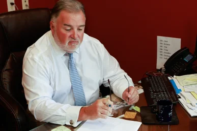 Lawyer joel hamner explains an intersection accident exhibit to a client, focusing on traffic signal timing.