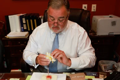 Lawyer joel hamner meets with a client to discuss a bus accident exhibit featuring collision diagrams and route data.