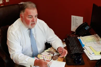 Lawyer joel hamner meets with a client to review a jogger accident exhibit featuring driver visibility data.
