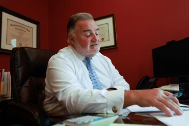 Lawyer joel hamner reviews a grain bin explosion exhibit with a client, pointing out blast pattern evidence.