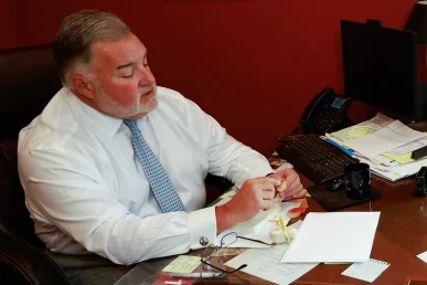 Lawyer joel hamner reviews a taxi accident exhibit with a client, including driver logs and witness statements.