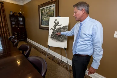 Lawyer tom mccutcheon discusses a motorcycle passenger injury exhibit emphasizing helmet damage analysis.