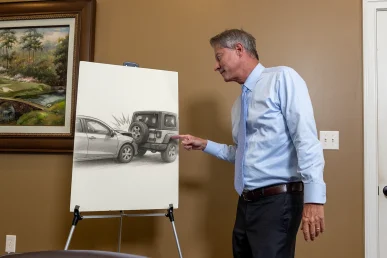 Lawyer tom mccutcheon discusses a rear end crash exhibit highlighting braking distances and impact speed.