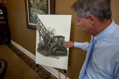Lawyer tom mccutcheon highlights an exhibit showing how a malfunctioning excavator caused a heavy machinery accident.