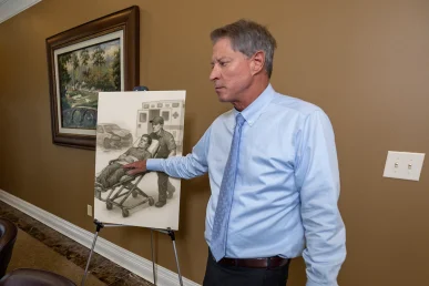 Lawyer tom mccutcheon highlights an organ damage injury exhibit showing medical imaging and treatment records.