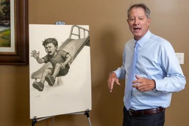 Lawyer tom mccutcheon reviews a child injury exhibit with playground photos and expert safety evaluations.
