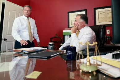 Lawyers tom mccutcheon and joel hamner review imaging scans for a neck and cervical spine injury case.
