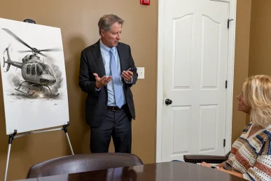 Personal injury attorney tom mccutcheon discusses a helicopter accident case with a client.
