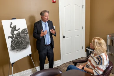 Personal injury attorney tom mccutcheon talks with a client about a motorcycle passenger injury case.