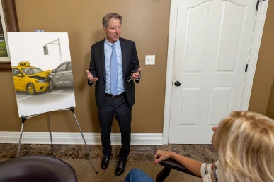 Personal injury attorney tom mccutcheon talks with a client about a taxi accident case.