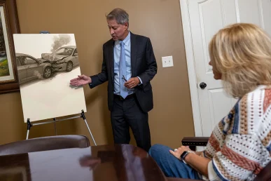 Personal injury attorney tom mccutcheon talks with a client about an automotive defects lawsuit during a private meeting.