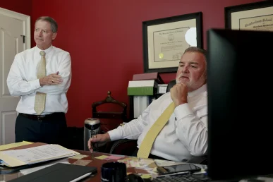 Tom mccutcheon and joel hamner discuss a slip and fall accident claim with a client during the consultation.