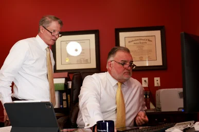Tom mccutcheon and joel hamner examine x rays with a client while evaluating a bone fracture injury claim.