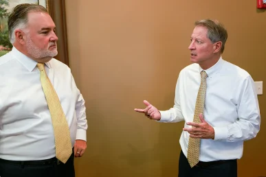 Tom mccutcheon and joel hamner examine evidence from a golf course vehicle collision case.