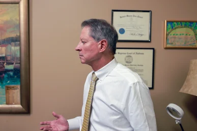 Tom mccutcheon and joel hamner meet in tom’s office to review a day care accident claim with a client.