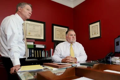 Tom mccutcheon and joel hamner meet with a client to discuss evidence in a talcum powder injury case.