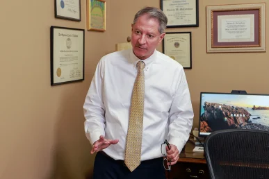 Tom mccutcheon and joel hamner meet with a client to review a gym and fitness center injury case.