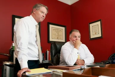 Tom mccutcheon and joel hamner review diagnostic images with a client regarding a neck injury case.