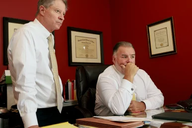 Tom mccutcheon and joel hamner sit with a client to evaluate a nursing home neglect or abuse case.