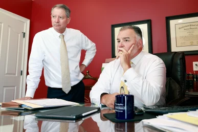 Tom mccutcheon and joel hamner talk with a client regarding compensation for painful joint injuries.