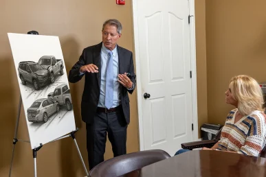 Tom mccutcheon consults with a client to review a multiple vehicle collision claim.