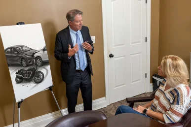 Tom mccutcheon discusses a motorcycle accident claim with a client in the conference room.