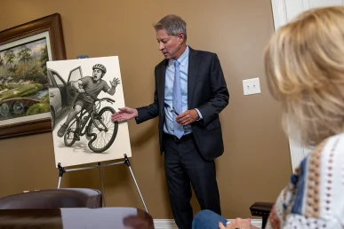 Tom mccutcheon reviews a bicycle accident case with a client in the mccutcheon & hamner conference room.
