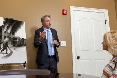 Tom mccutcheon reviews a fire related accident claim with a client in the conference room.