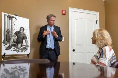 Tom mccutcheon talks with a client about a gym and fitness center injury claim.