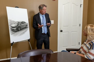 Tom mccutcheon talks with a client about a hit and run accident claim in the conference room.