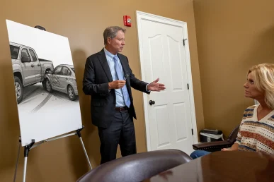 Tom mccutcheon talks with a client about a side swipe accident claim in the conference room.