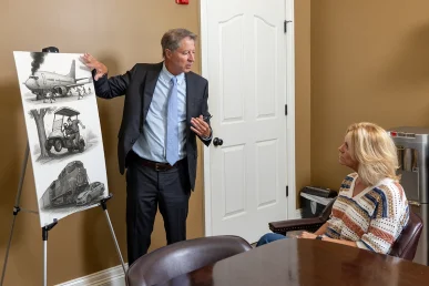 Tom mccutcheon talks with a client about other vehicle accident claims in the conference room.