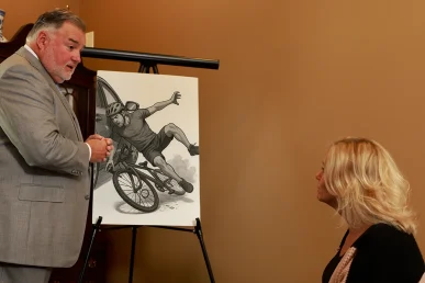 Attorney Joel Hamner discusses a bicycle accident with a client, highlighting an illustration of the incident.