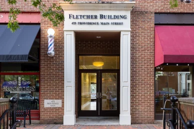 The entrance to the Fletcher Building in Huntsville, featuring double doors and a stone address marker.
