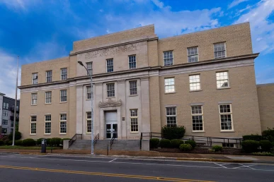Historic federal courthouse in Huntsville, Alabama; features a prominent entrance and large windows under a blue sky.