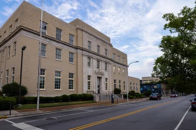 Historic Huntsville Federal Courthouse viewed from the front right, featuring a light brick facade and visible entrance.