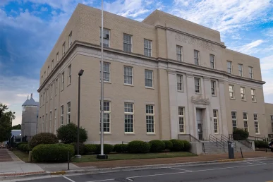 Historic Huntsville federal courthouse viewed from the front right, showcasing its architecture and surrounding greenery.