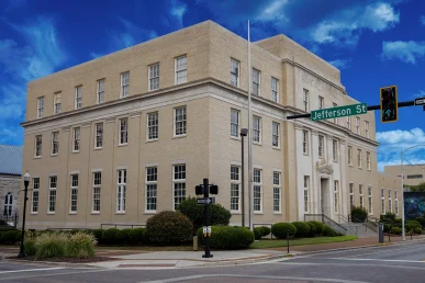 Historic Huntsville federal courthouse at the corner of Jefferson St, showcasing its architectural detail and landscaping.