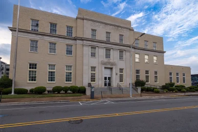 Historic Huntsville federal courthouse features a beige brick facade and a prominent entrance with steps and signage.