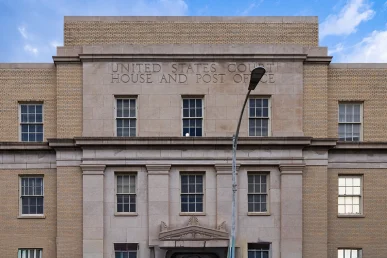 Close-up view of the entryway of the Historic Huntsville federal courthouse, featuring stone details and windows.
