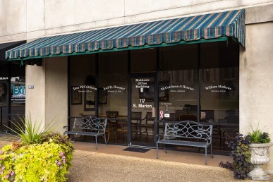 McCutcheon & Hamner's office in Athens, Alabama, features glass doors and benches outside under a striped awning.